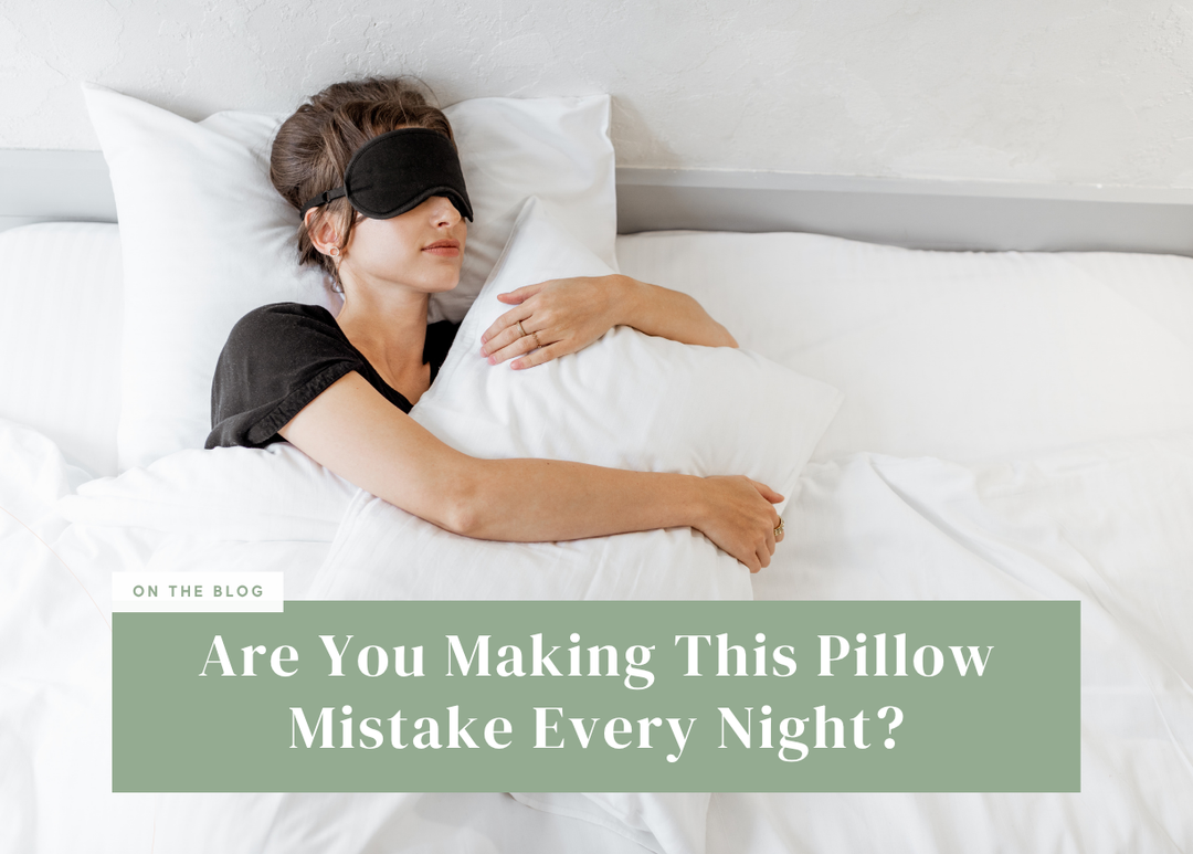 Woman wearing a sleep mask hugging a pillow in bed.