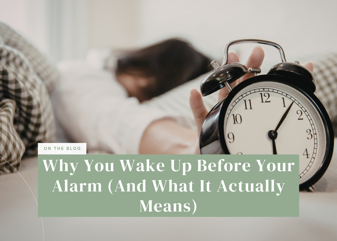 Alarm clock on a nightstand beside someone sleeping in bed