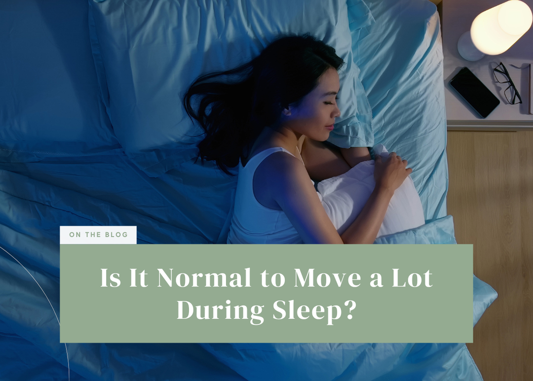 Woman hugging a pillow while lying on her side in bed at night.