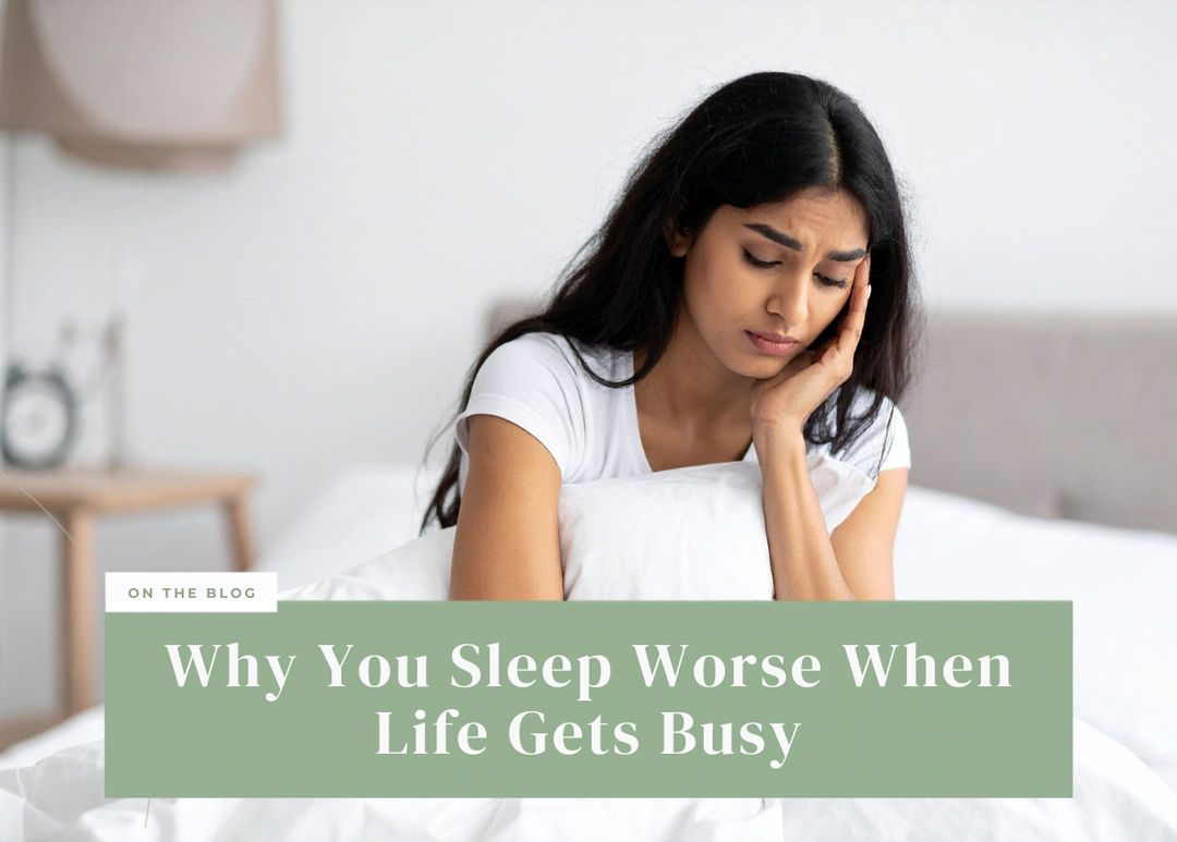 Woman sitting in bed hugging a white pillow with a troubled, restless expression.