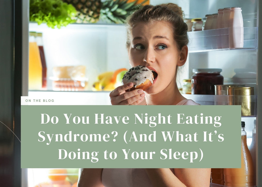 Woman taking a bite out of a frosted donut late at night in front of an open refrigerator.