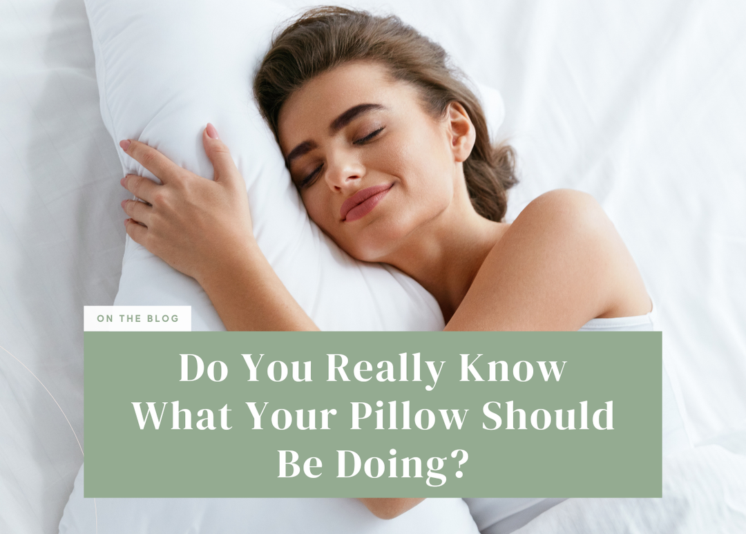 Woman smiling with her eyes closed while hugging a fluffy white pillow in bed.