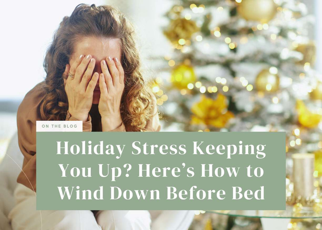 Stressed woman covering her face with her hands in front of a Christmas tree.