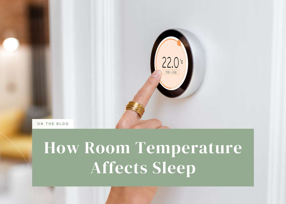 Hand pressing a button on a wall-mounted digital thermostat.