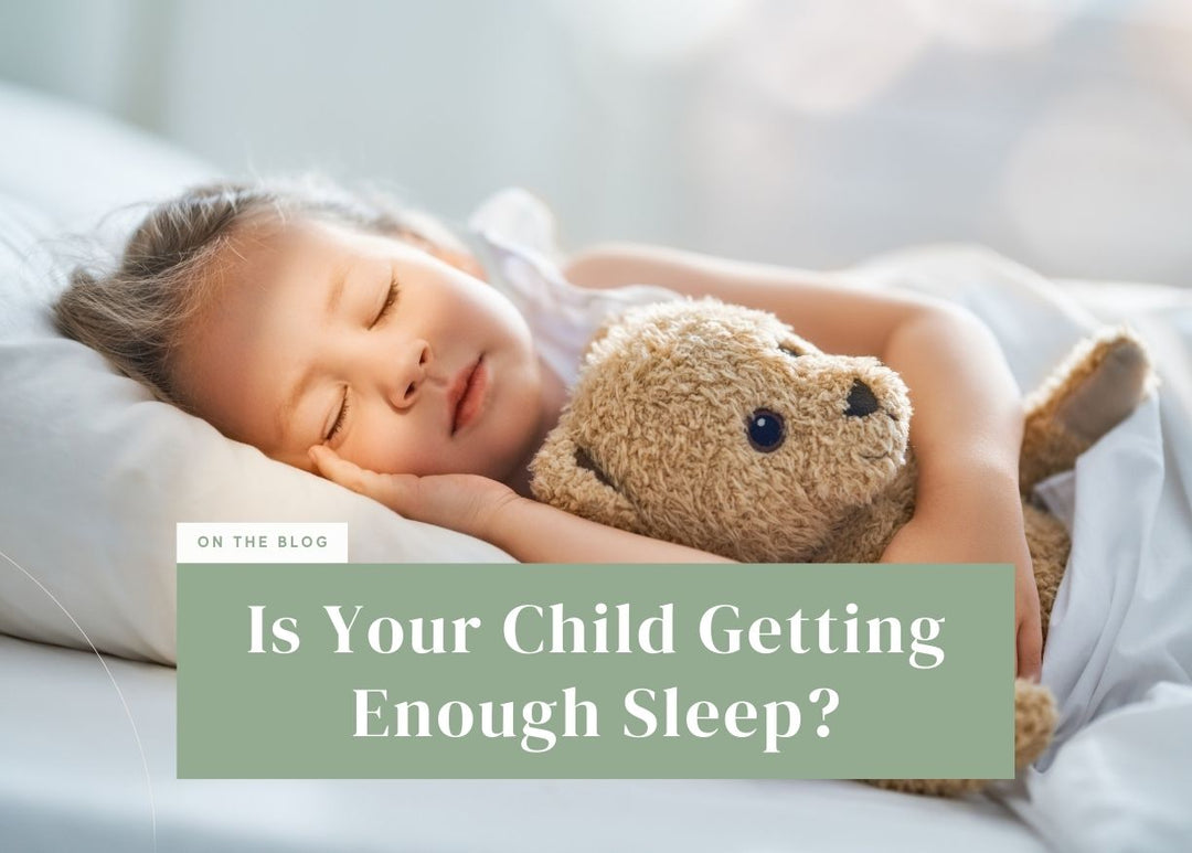 Young girl sleeping peacefully while hugging a teddy bear.