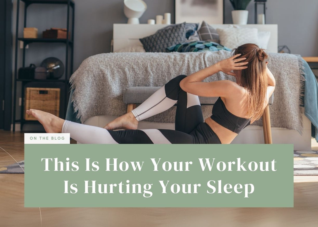 Woman doing bicycle crunches on a mat in front of her bed.