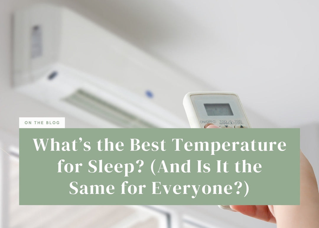 Hand holding an air conditioner remote pointing it toward a wall-mounted unit.